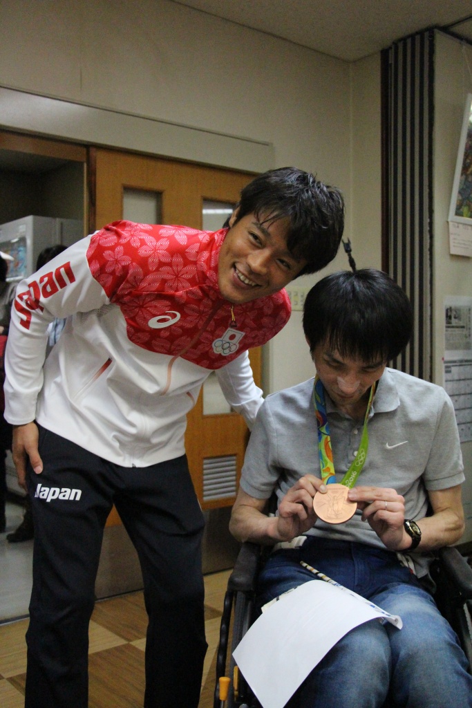 羽根田選手にメダルをかけさせてもらい笑顔の利用者さん