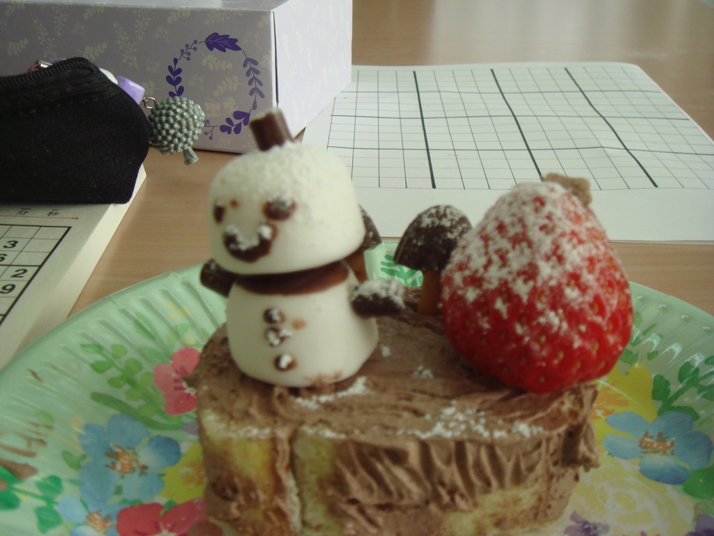 雪だるまとイチゴが乗ったケーキの写真