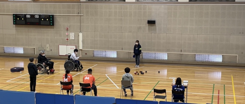 ボッチャ大会でボールを投げた瞬間の宮崎さん。審判団と相手の選手が見守る中堂々たる投球です。