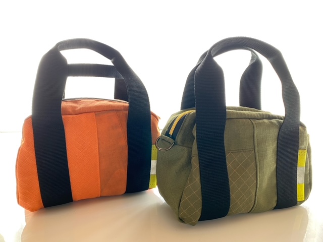 消防服をアップサイクルして作製した手さげバッグ。色は緑とオレンジがあります。